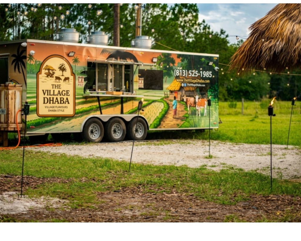 The Village Dhaba food truck beside the thatched pavilion at dusk